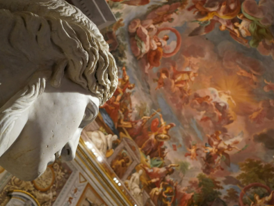 Scultura bianca classica di un uomo inquadrata nel solo viso mentre guarda un soffitto affrescato