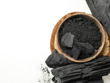 Immagine che mostra del carbone nero su sfondo bianco
