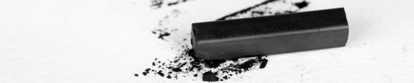 Immagine di un pezzo di carbone su sfondo bianco mentre  si sbriciola