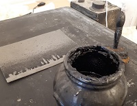 Vernicetta, pennello e lastra di zinco in lavorazione